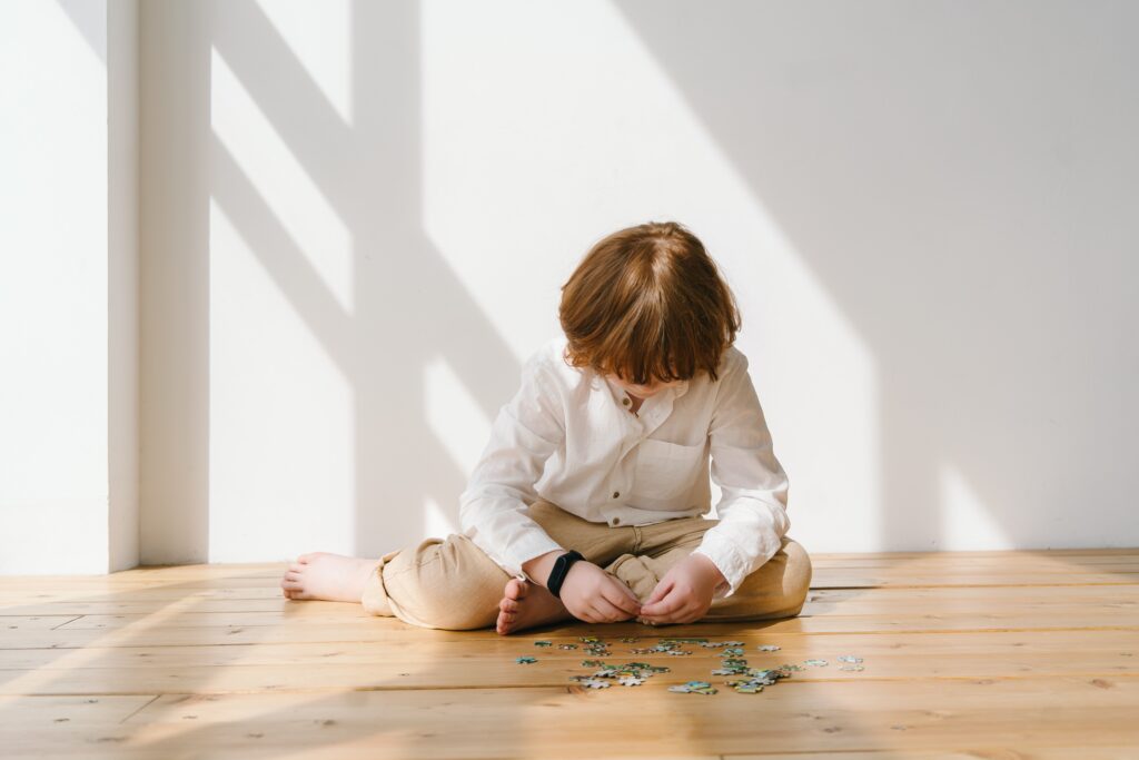 Little boy plays and interacts with toys while being observed for his ASD Assessment.