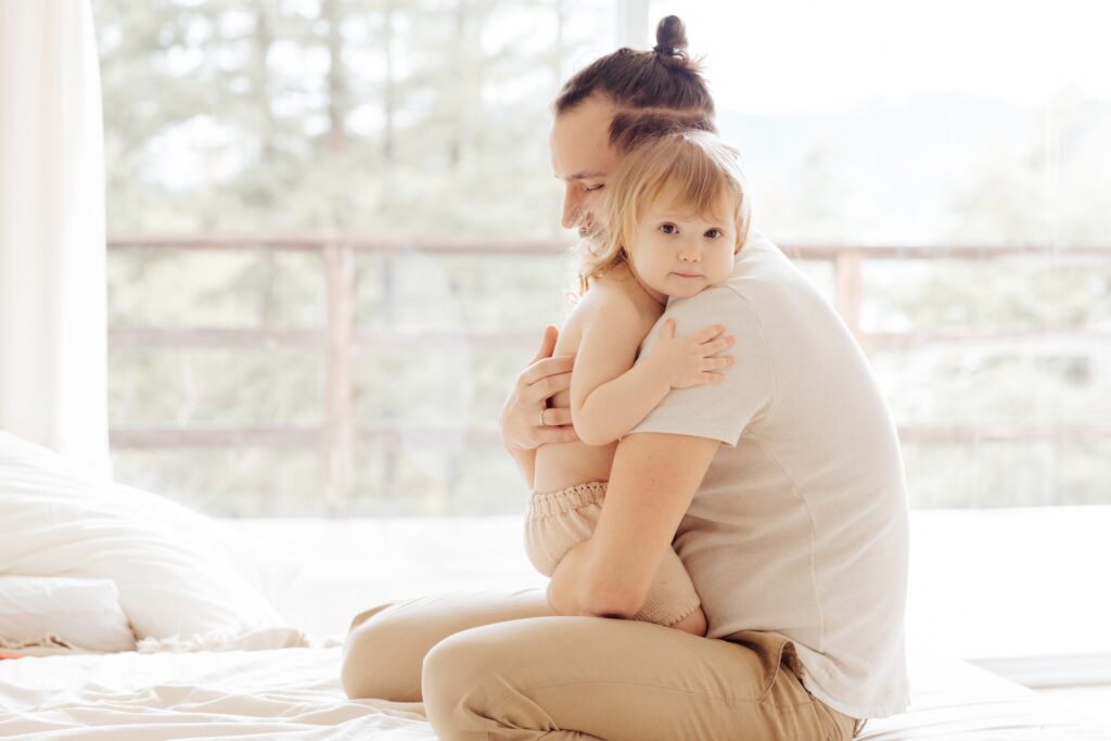 Father hugs their child as a support for their shown ASD behaviour symptoms.