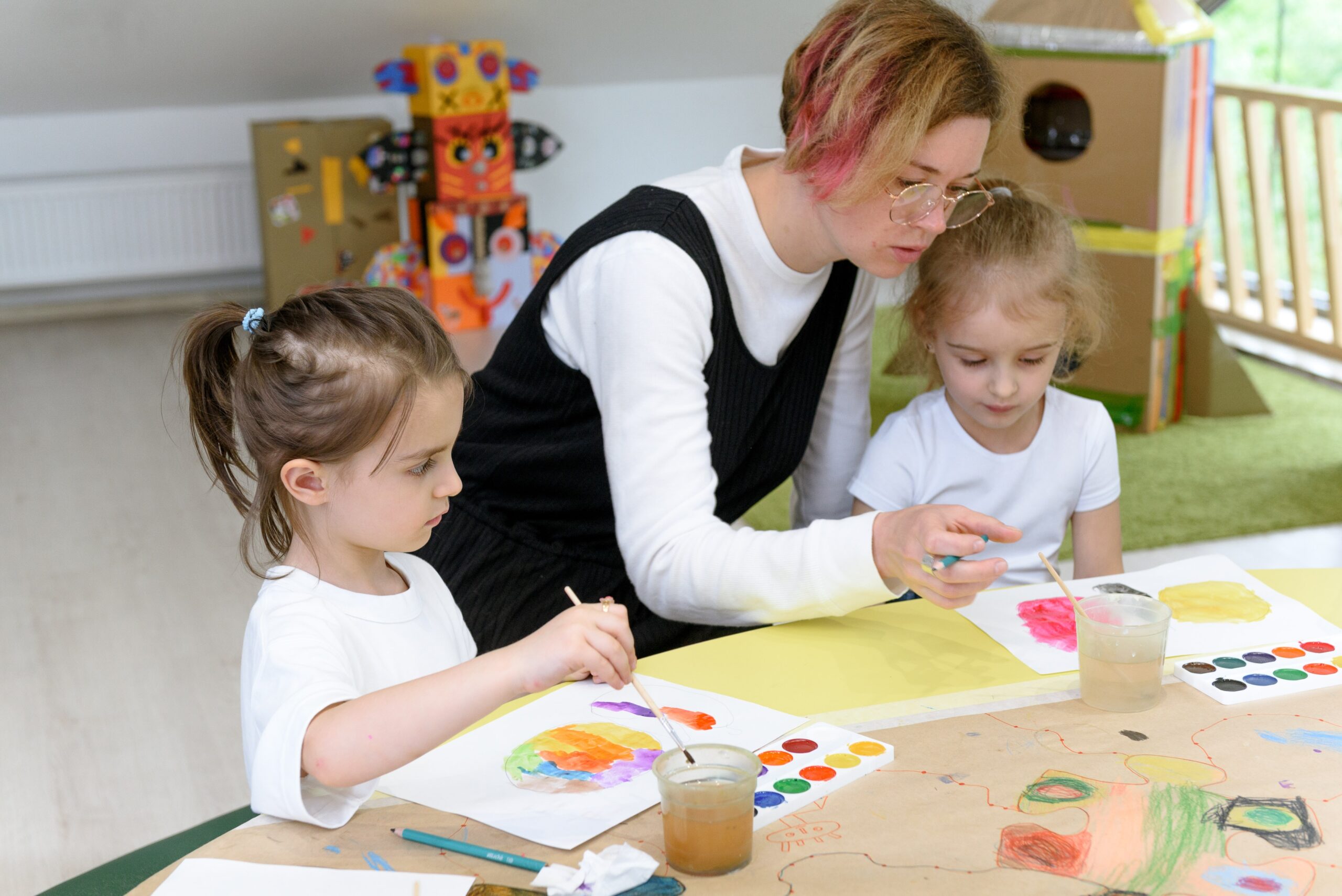 Mother helping and supporting her daughters practise drawing and painting while waiting for an official ADHD diagnosis.